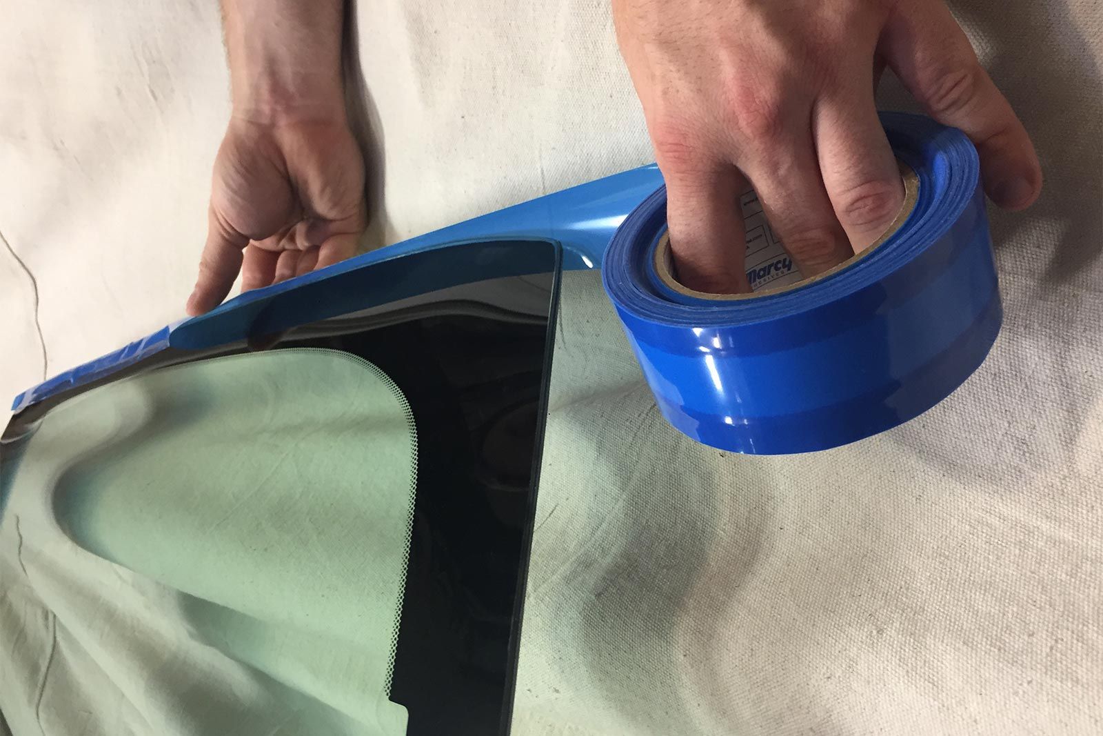 Marcy edge tape being applied to auto glass